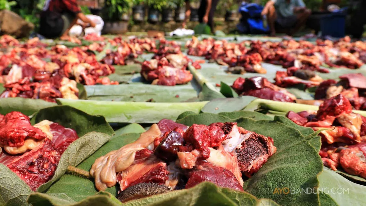 Warga membungkus daging kurban dengan daun tisuk dan daun pisang di Kampung Berseri Astra (KBA) Cidadap Ecovillage, Desa Padalarang, Kecamatan Padalarang, Kabupaten Bandung Barat, Rabu 19 Juni 2024. 