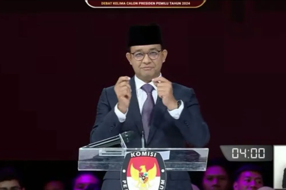Tampak Anies Baswedan menggunakan bahasa isyarat dengan menunjuk jam tangannya dalam debat capres terakhir.