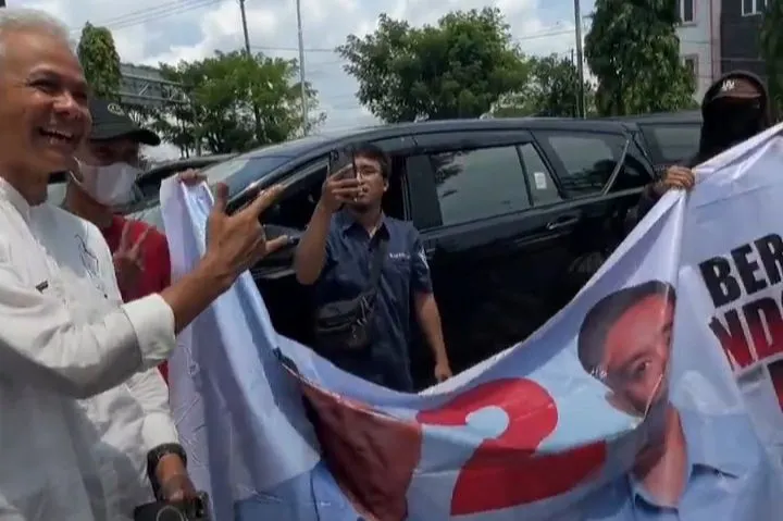 Ganjar berfoto bersama pendukung 02 yang membentangkan spanduk Prabowo Gibran di Balikpapan pada Selasa 6 Februari 2024