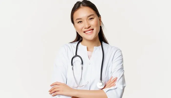 Asian female doctor, physician in medical uniform with stethoscope, cross arms on chest, smiling and looking like professional, white background.
