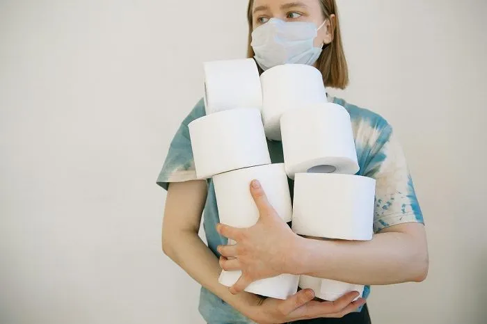 Gambar seorang wanita sedang menimbun barang yaitu tissue dalam jumlah yang banyak. 