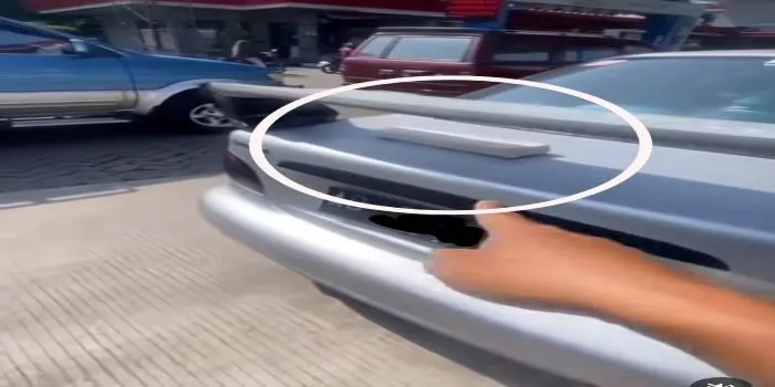 Sebuah Tempe Nangkring di Atas Bemper Mobil yang sedang Antri BBM di SPBU