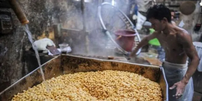 Pekerja mengolah kedelai untuk membuat tempe dan tahu.