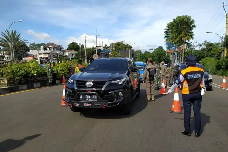 Petugas gabungan saat melakukan pemeriksaan surat keterangan sehat kepada wisatawan, di Simpang Gadog, Ciawi, Kabupaten Bogor.