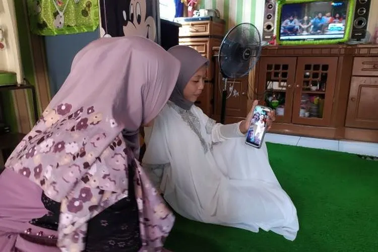 Salah satu warga saat melakukan panggil video dengan sanak saudaranya di kampung halaman/ Yogi Faisal