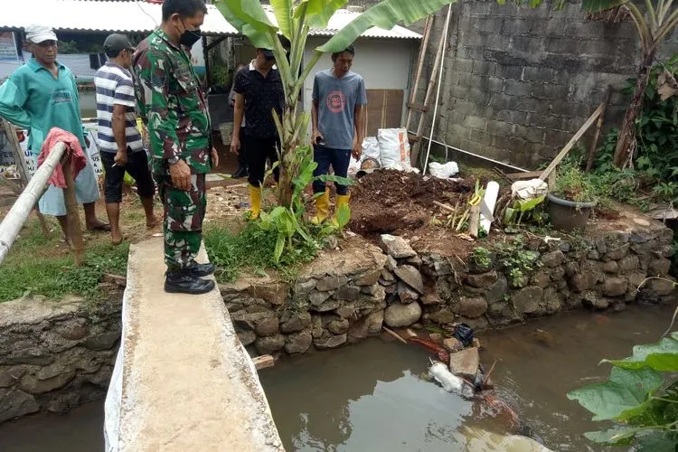 Petugas saat melakukan evakuasi jasad bayi, yang tersangkut di bebatuan Kali Cimahpar. (Dok. Polsek Cibinong)