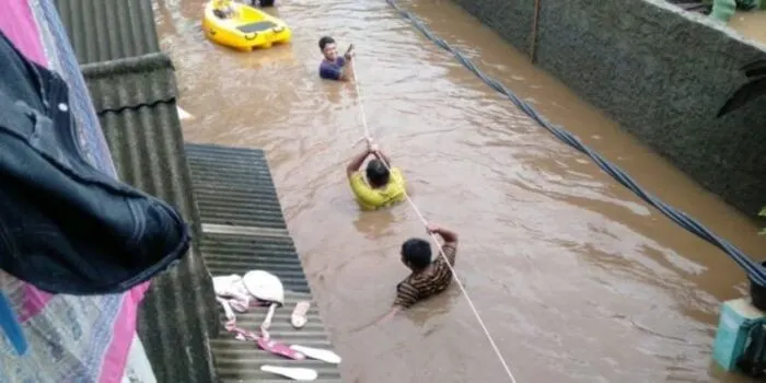 Petugas mengevakuasi korban banjir di Cipinang Melayu, Makasar, Jakarta Timur menggunakan bentangan tali tambang untuk menerobos arus air, Minggu (23/2/2020). Banjir yang merendam ratusan rumah warga dipicu luapan Kali Sunter. 