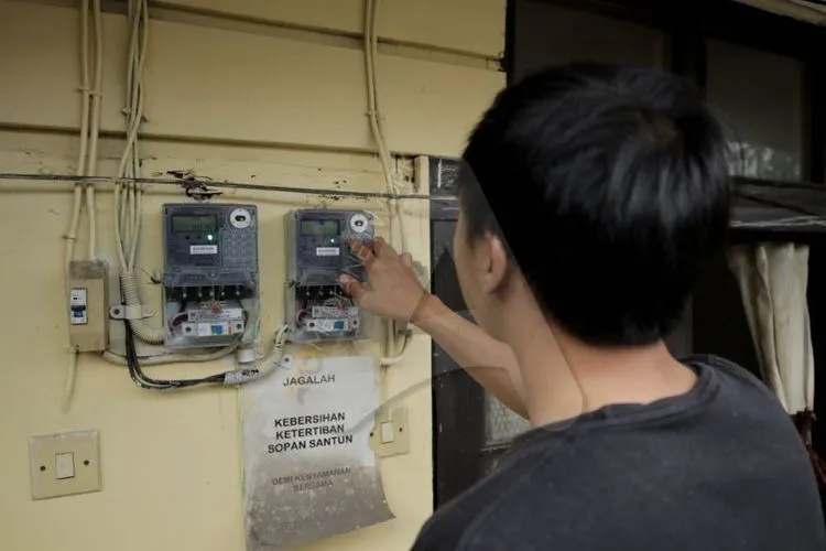 Seorang warga memasukan nomer token listrik