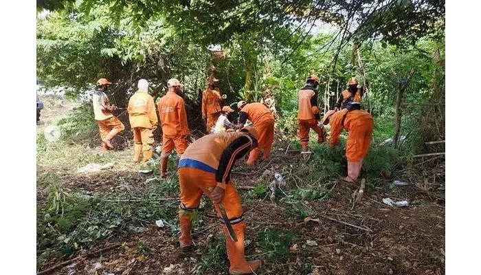 Para petugas PPSU (Penanganan Sarana dan Prasarana Umum) sedang melaksanakan kegiatan membersihkan lingkungan yang tercemar oleh sampah plastik