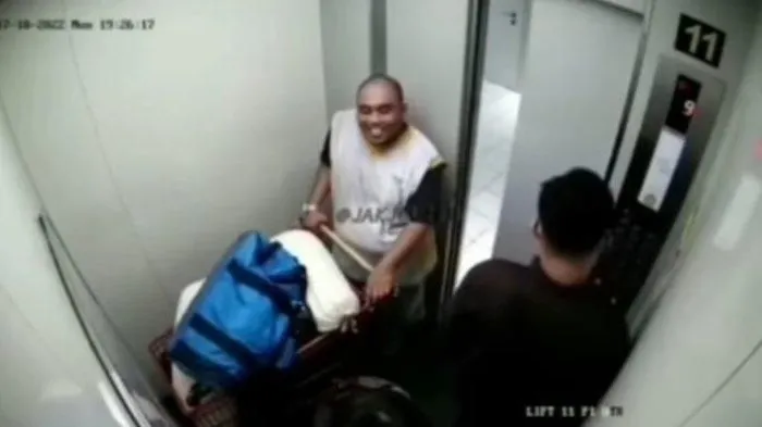 Christian Rudolf Tobing tertangkap kamera CCTV tersenyum saat membawa mayat yang terbungkus tas.