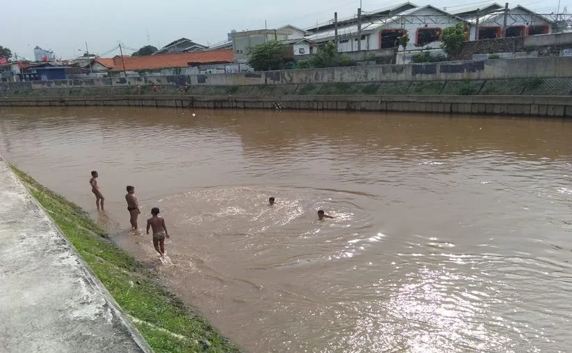 Anak-anak yang tinggal di wilayah bantaran Sungai Ciliwung, Jatinegara, Jakarta Timur, memanfaatkan sungai tersebut untuk bermain dan berenang.