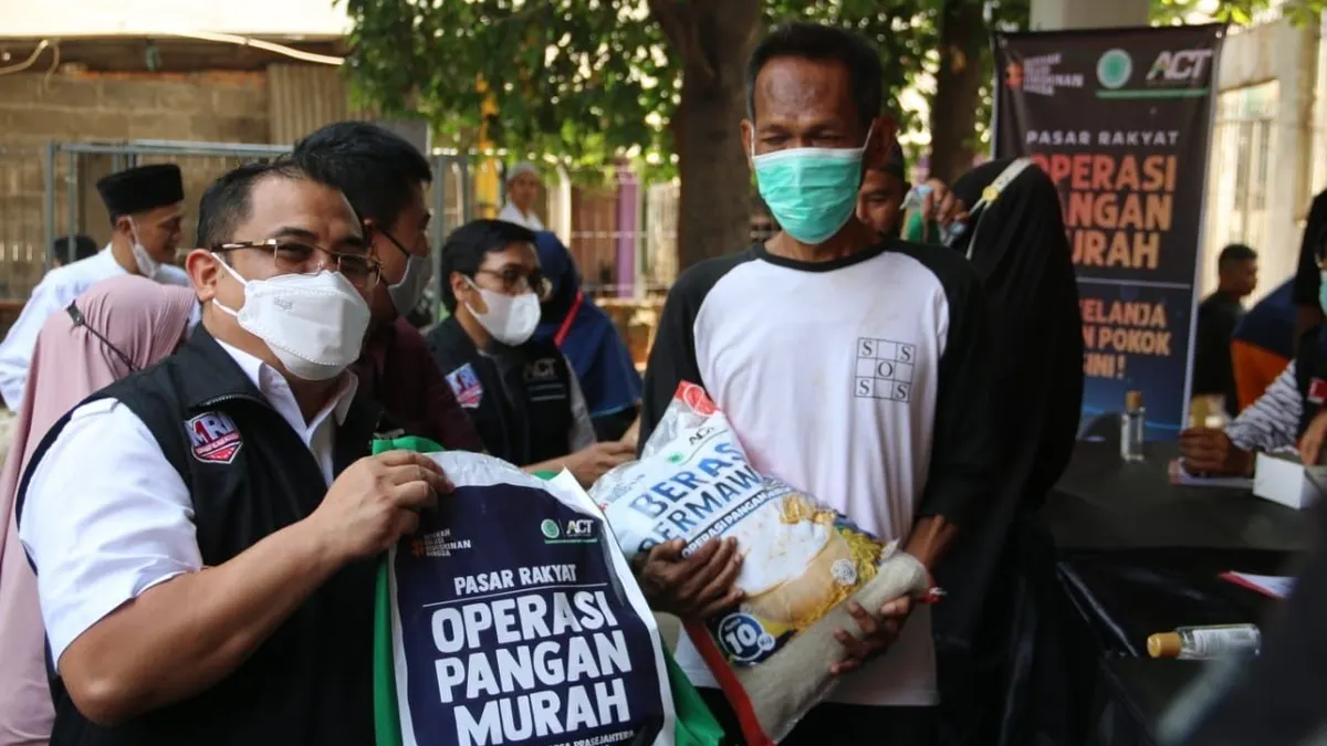 Presiden ACT Ibnu Khajar (kiri) saat memberikan paket sembako dalam Operasi Pangan Murah di Masjid Assuada, Kecamatan Koja, Jakarta Utara, Jumat 15 Oktober 2021. 