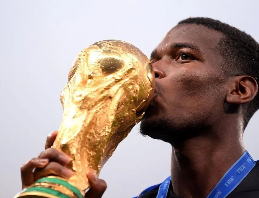 Sosok Paul Pogba mencium trofi Piala Dunia. Bersama Timnas Perancis, Pogba memenangkannya di Piala Dunia 2018 di Rusia (Instagram @Paulpogba)