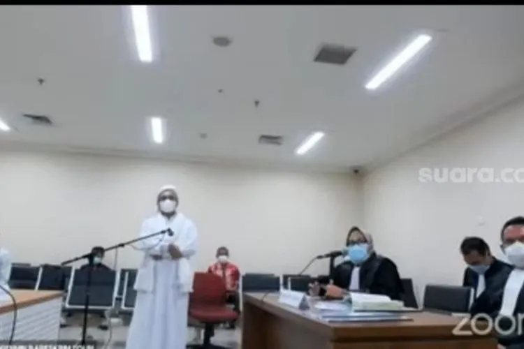 Habib Rizieq melakukan aksi berdiri dan bungkam selama persidangan, Jumat (19/3/2021). [Suara.com/ Bagaskara Isdiansyah]