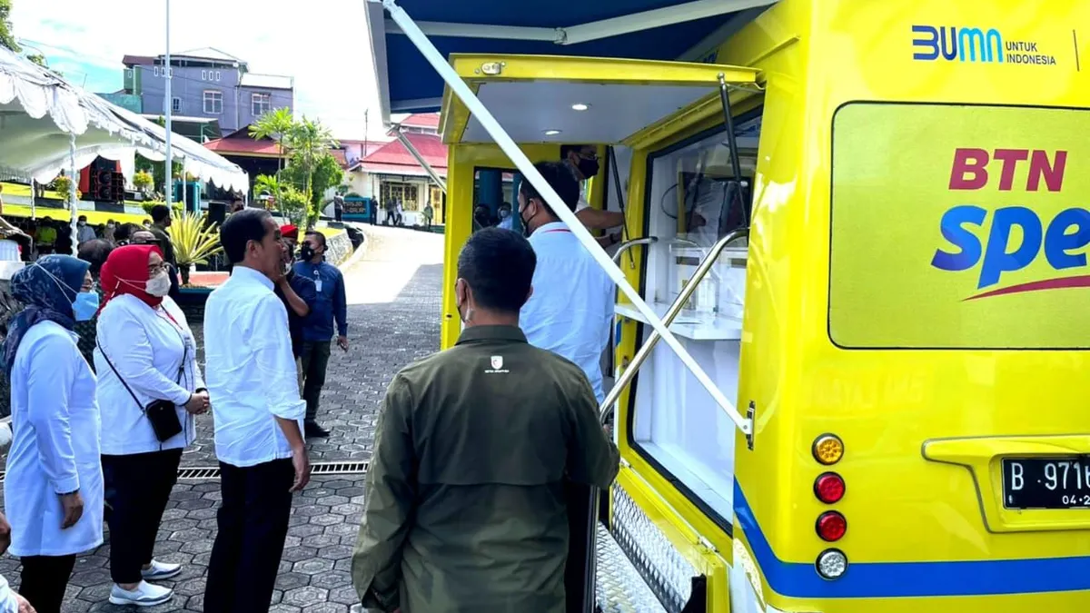 Presiden Jokowi didampingi Menteri Ketenagakerjaan Ida Fauziyah menyaksikan peserta penerima Bantuan Subsidi Upah (BSU) melakukan penarikan dana melalui ATM pada Mobil Kas Keliling (MKK) Bank BTN di Ternate, Maluku Utara, Selasa (27/9/2022).