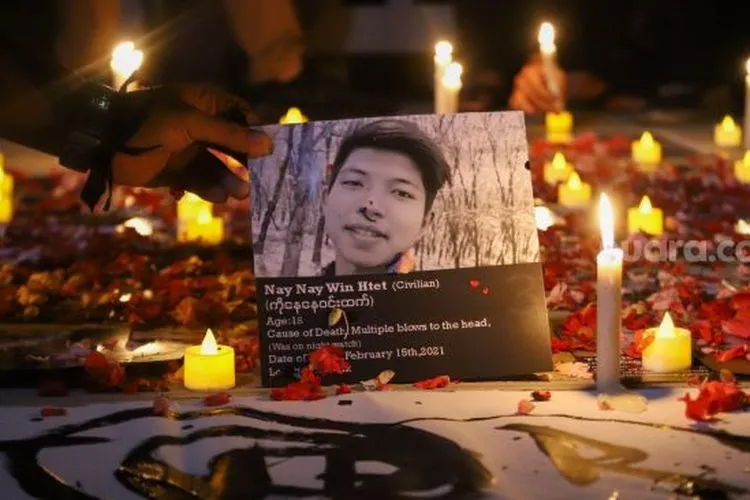 Massa saat akan menaruh salah satu foto wajah korban tewas akibat kudeta militer saat aksi solidaritas untuk Myanmar di depan Gedung ASEAN, Jakarta, Jumat (12/3/2021). [Suara.com/Alfian Winanto]