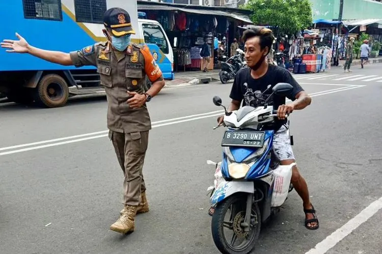 Salah satu warga yang mengendarai sepeda motor di Jalan Lorong 104 Permai, Koja tidak memakai masker dan dirazia Satpol PP/dok: utara.jakarta.go.i