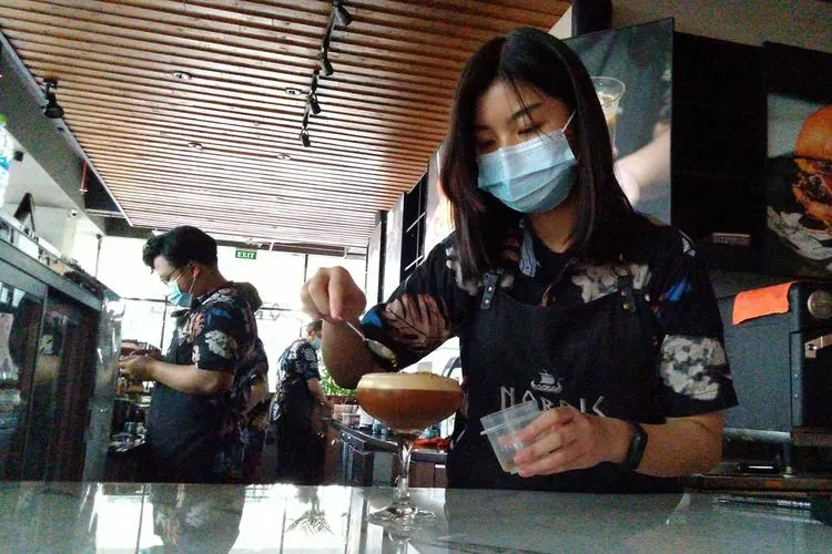 Karyawan Nordic Cafe menyajikan menu andalan kopi mereka saat Grand Opening di Marvell City Surabaya, Minggu (7/3/2021). (Ayosurabaya/Praditya)