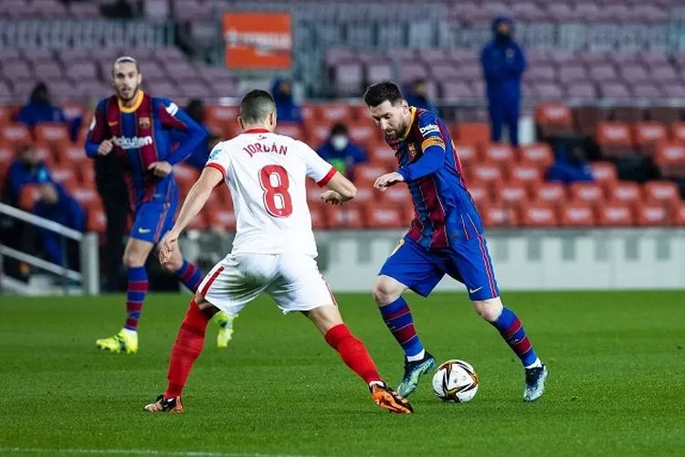 Lionel Messi berusaha melewati adangan pemain Sevilla, Jordan di leg kedua semifinal Copa del Rey 2020/2021. (Twitter Barcelona)