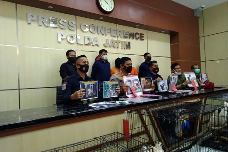 Personel Ditreskrimsus Polda Jatim dan BBKSDA menunjukan tersangka beserta sejumlah satwa langka yang diamankan saat press release, Rabu (17/2/2021).