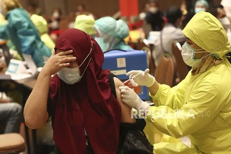 Seorang wanita menerima suntikan vaksin COVID-19 Sinovac saat vaksinasi massal untuk pedagang dan pekerja di sebuah pusat perbelanjaan di Tangerang, Indonesia, Senin, 1 Maret 2021.  Foto: AP/Tatan Syuflana