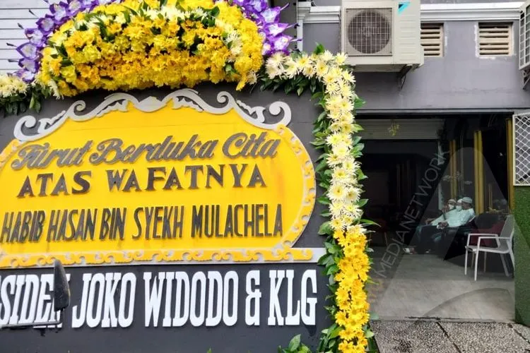 Karangan bunga ucapan duka cita dari Presiden Joko Widodo terpampang di depan rumah duka Habib Hasan Mulachela di kawasan Pasarkliwon, Solo, Jumat (12/3/2021). (Ayojakarta/Budi Cahyono)