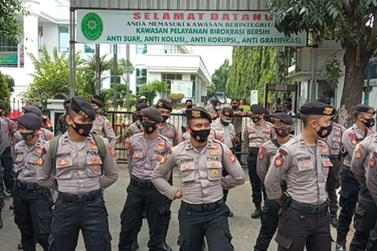 Petugas kepolisian berjaga di depan gerbang Pengadilan Negeri Jakarta Timur. (Ayojakarta.com/Fichrihakiim)