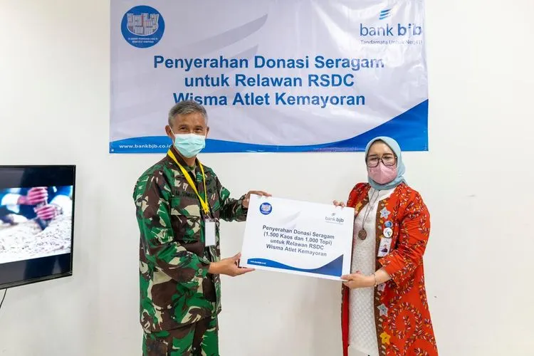 Direktur Konsumer dan Ritel bank bjb Suartini menyerahkan bantuan kepada Kepala Sekretariat Koordinator RSD Penanganan Covid-19 Wisma Atlet Kemayoran Letkol Kes dr. Mintoro Sumego dan Humas RSD Penanganan Covid-19 Wisma Atlet Kemayoran Letkol Laut drg. Muhammad Arifin di Jakarta, Rabu (24/3/2021). (istimewa)