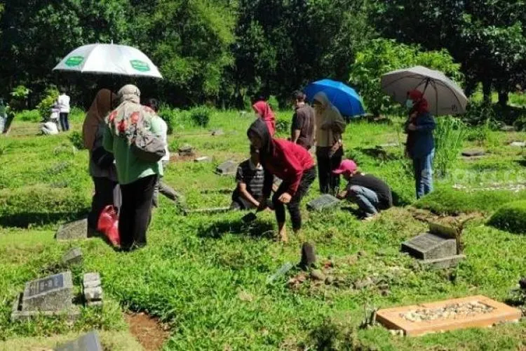 Padatnya para peziarah ke makam dimanfaatkan para pembersih makam untuk mengais rezeki. (dok Suara.com)