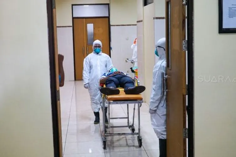 Petugas kesehatan dengan menggunakan APD menangani pasien yang diduga terindikasi virus corona saat simulasi penanganan pasien yang terdeteksi virus corona di RS Margono Soekarjo Purwokerto, Senin (3/1/2020). (Suara.com/Anang Firmansyah).