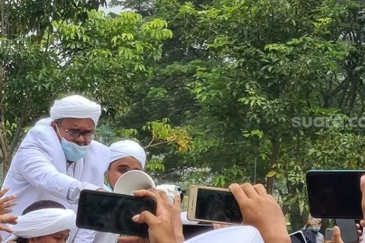 Habib Rizieq Shihab saat menyapa simpatisan yang mengawal kepulangan di Bandara Soetta. (Suara.com/Stephanus Aranditio)
