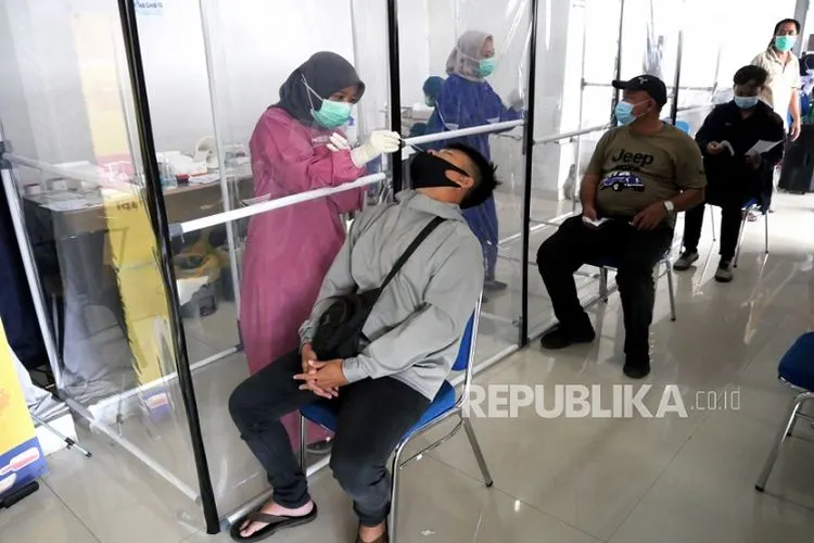Petugas medis melakukan pengambilan sampel tes cepat antigen penumpang kereta api jarak jauh.  Foto: Wihdan Hidayat / Republika
