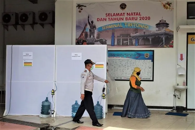 Petugas Terminal Tipe A (TTA) Tirtonadi Solo mengawasi penumpang yang masuk ke bilik disinfektan untuk mencegah paparan Covid-19. (Ayojakarta/Budi Cahyono)