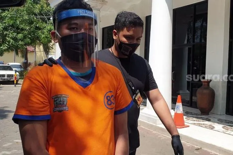 Gilang Aprilian Nugraha (22) yang membungkus korbannya dengan kain jarik berkedok tugas penelitian dan riset saat diarak menuju tahanan Mapolrestabes Surabaya, Sabtu (8/8/2020). [Suara.com/Arry Saputra]