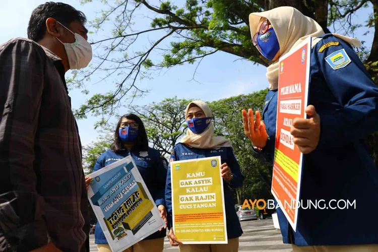 Petugas Satuan Polisi Pamong Praja (Satpol PP) Kota Bandung melakukan sosialisasi penggunaan masker dan denda bagi yang tidak menggunakan masker di lingkungan Balai Kota Bandung, Jalan Wastukancana, Kota Bandung, Kamis (6/7/2020).(Ayobandung.com/Irfan Al-Faritsi)