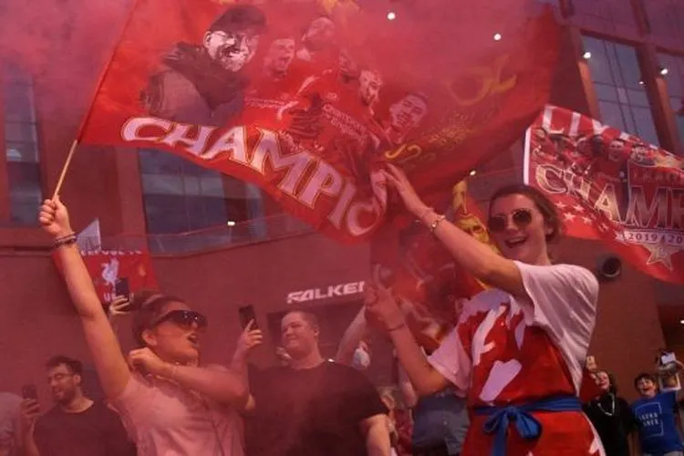 Di tengah pandemi COVID-19, sekelompok fans Liverpool melakukan perayaan di luar Stadion Anfield, Liverpool, Jumat (26/6/2020) dini hari WIB. Liverpool dipastikan menjuarai Liga Inggris 2019/2020 usai kekalahan 1-2 Manchester City di markas Chelsea. [OLI SCARFF / AFP]