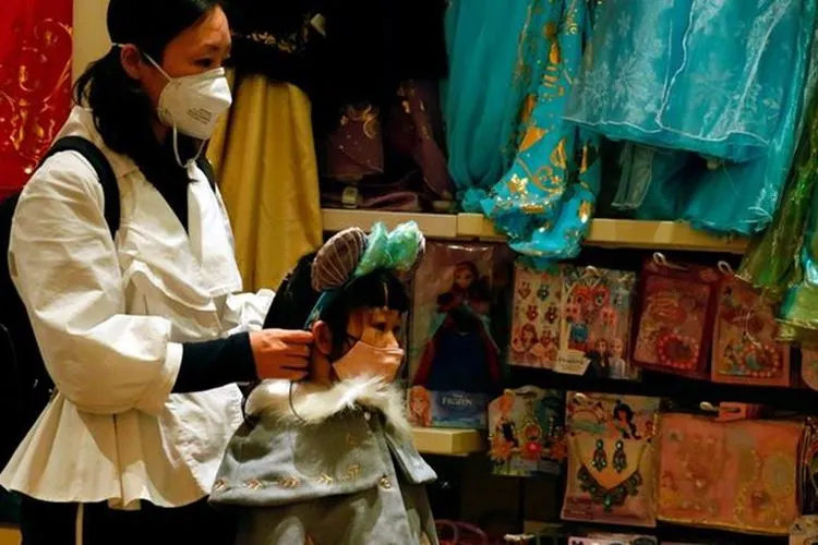 Seorang wanita dewasa dan seorang anak kecil memakai masker di sebuah toko suvenir di Hong Kong mengantisipasi penyebaran wabah virus Corona, 26 Januari 2020. (Bisnis.com/Reuters/Tyrone Siu)