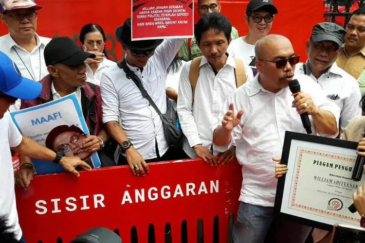 Azas Tigor Nainggolan (berkepala plontos) bersama Aliansi Masyarakat untuk Transparansi memberikan piagam penghargaan kepada anggota DPRD DKI Jakarta Fraksi PSI, William Aditya Sarana, karena membongkar kejanggalan dalam perencanaan APBD DKI Jakarta 2020. (Ayojakarta.com/Aprilia Rahapit)
