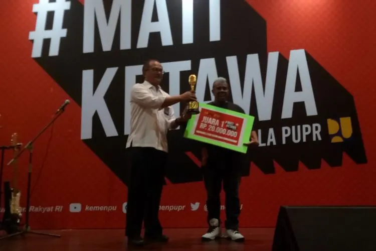 Reinold Lawalata menerima hadiah usai menjuarai kompetisi Stand Up Komedi #MATIKETAWA ala PUPR dengan hadiah sebesar Rp 20 juta (Ayojakarta.com/Lopi Kasim