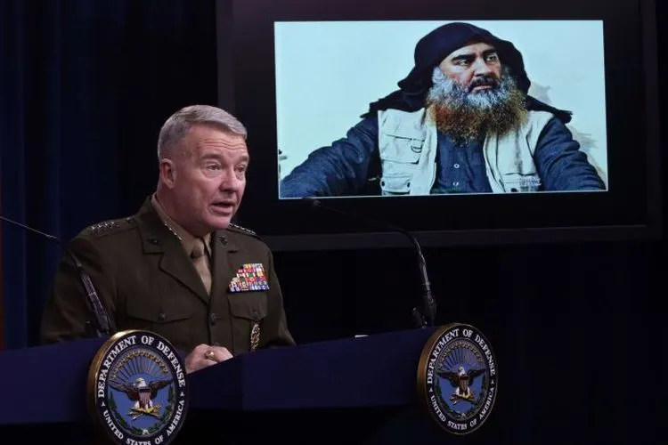 Komandan Komando Pusat AS Jenderal Marinir Kenneth McKenzie berbicara dengan latar belakang foto Abu Bakr Al-Baghdadi/AFP