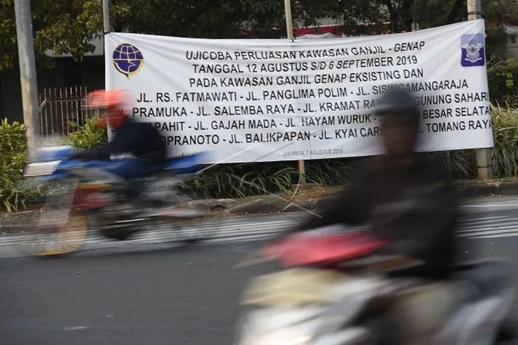 Pengendara sepeda motor melintasi spanduk sosialisasi perluasan aturan ganjil genap di Jalan Veteran, Jakarta Pusat. (Antara)