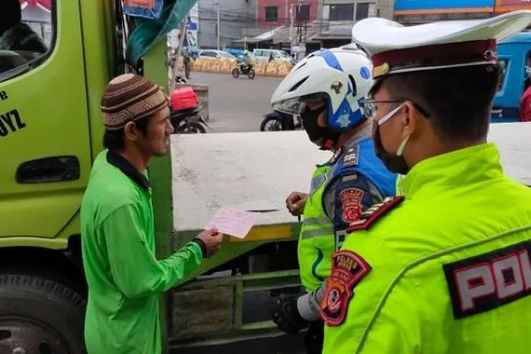 Polisi saat memberikan teguran tertulis kepada pengendara yang tak bermasker saat penerapan PSBB di Bogor. (Dok Lantas Polres Kabupeten Bogor).