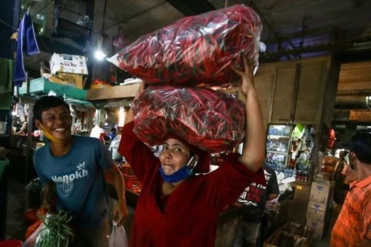 Seorang pedagang di Pasar Senen, Jakarta Pusat, membawa cabai di atas kepalanya, Senin (2/11/2020). [ANTARA/Rivan Awal Lingga]