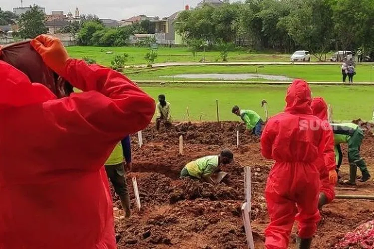 Petugas menggali makam untuk jenazah pasien Covid-19 di TPU Bambu Apus, Jakarta Timur. (Suara.com/Bagaskara)