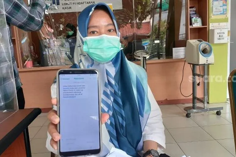 Dyna Fairuz Maharani, salah satu nakes Puskesmas Jurang Mangu, Kecamatan Pondok Aren, Tangsel, menunjukkan surat undangan vaksinasi Covid-19, Rabu (13/1/2021). [Suara.com/Wivy]