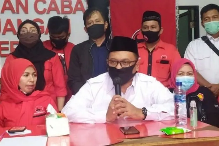 Calon wali kota Depok Pradi Supriatna (pegang mik) didamping calon wakil wali kota Afifah Alia (kiri) saat menjelaskan turunnya rekomendasi pencalonan mereka di kantor DPC PDI Perjuangan Depok, Jumat 17 Juli 2020/suara.com /Supriyadi