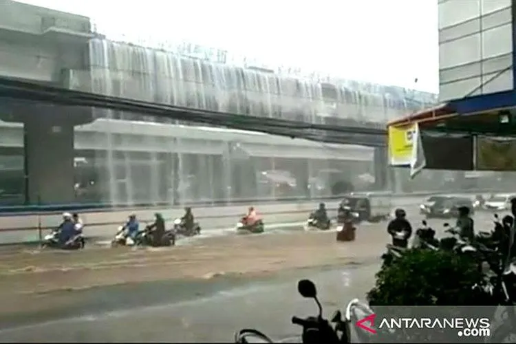 Pemandangan langka ketika para pengendara  melintas di bawah air terjun yang berasal dari badan Jalan Tol Becakayu, di kawasan Pondok Kelapa, Jakarta Timur yang berbatasan dengan Kota Bekasi, Jawa Barat, Kamis (21/11/2019). (Antara/Andi Firdaus)