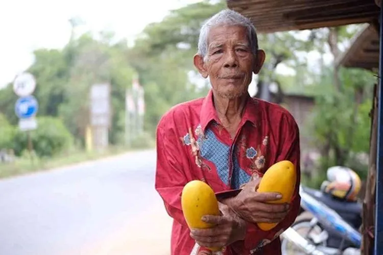Akim dengan timun suri yang dijajakan. (Ayobekasi.net/Firda Puri)