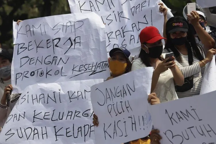 Sejumlah massa yang tergabung dalam Asosiasi Pengusaha Hiburan Jakarta (Asphija) membentangkan poster saat melakukan aksi unjuk rasa di depan Balai Kota DKI Jakarta, Selasa (21/7/2020). [Suara.com/Angga Budhiyanto]