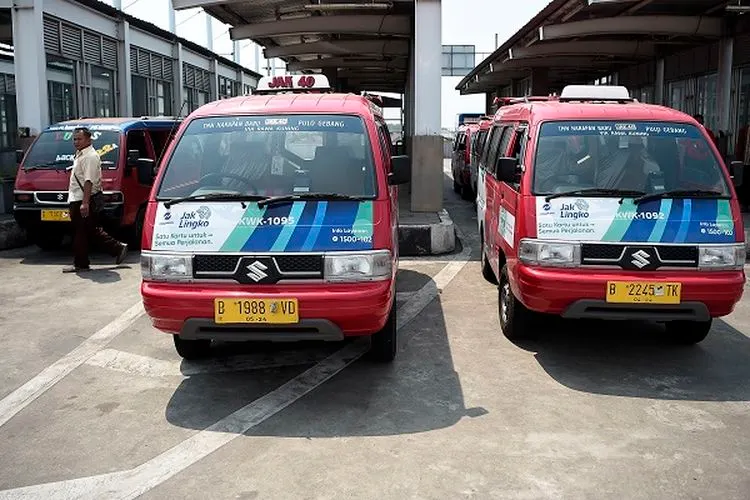 Warga melintas di antara mobil-mobil angkutan kota (Angkot) di Terminal Bus Terpadu Pulogebang, Jakarta Timur, Jumat (2/8/2019). Melalui Instruksi Gubernur DKI Jakarta Nomor 66 Tahun 2019 tentang Pengendalian Kualitas Udara, Gubernur Anies Baswedan melarang angkutan umum berusia di atas sepuluh tahun dan yang tidak lulus uji emisi beroperasi di jalanan Ibukota pada 2020, serta akan mengebut peremajaan 10.047 unit angkutan melalui program Jak Lingko pada 2019 ini. (ANTARA FOTO/Aditya Pradana Putra)